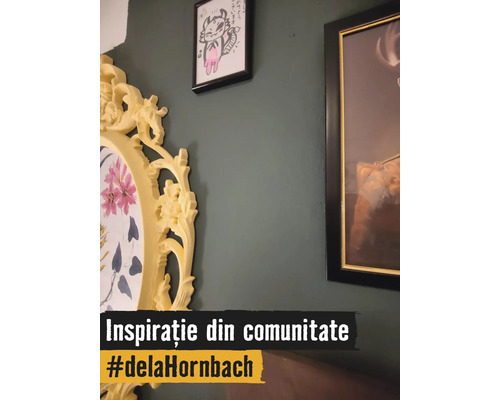 Decor de perete cu diverse rame foto pe un perete verde închis, inclusiv o ramă ovală galbenă, decorată, cu motiv floral.