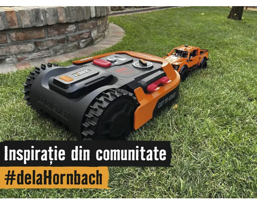 Robot de tuns gazonul cu roți pentru teren accidentat pe o peluză lângă o mașină de jucărie.