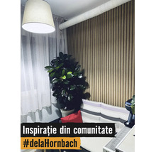 Living modern cu panou de perete din lamele verticale de lemn, plantă de apartament, perdele albe și canapea cu perne în dungi.
