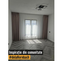 Cameră modernă cu pardoseală tip spic, perdele în culori deschise și plafonieră cu design geometric.