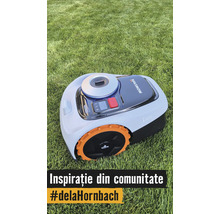 Robot de tuns gazonul Navimow i105 pe iarbă cu roți portocalii și panou de control.