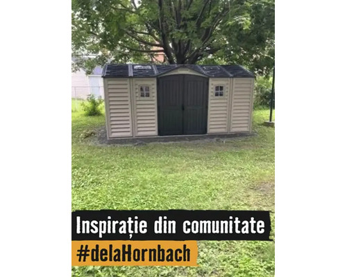 Șopron de grădină spațios din plastic cu acoperiș în două ape, ușă dublă și ferestre pe un gazon în grădină.