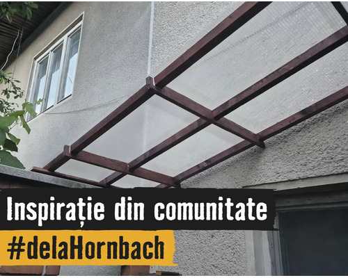 Copertină pentru terasă cu cadru din lemn și plăci translucide montată pe peretele exterior al casei.