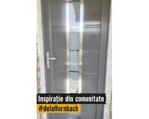 Ușă de intrare gri modernă cu inserție verticală de sticlă, două benzi metalice și mâner argintiu.