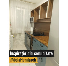 Bucătărie modernă și compactă cu dulapuri albastru deschis, blat de lucru din lemn, chiuvetă neagră, plită vitroceramică și cuptor încorporabil.