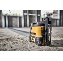 Laser cu linii în cruce DeWalt pe o podea de beton într-o clădire în construcție pentru aliniere precisă.