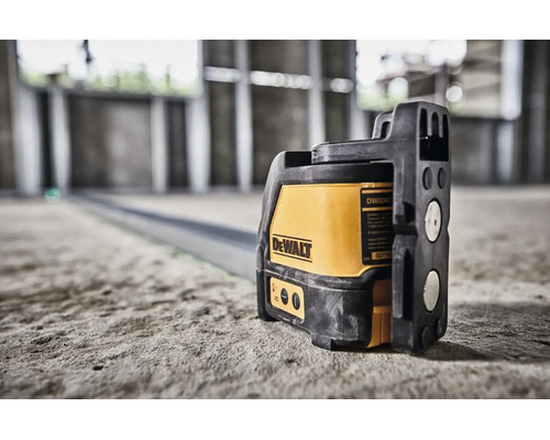 Laser cu linii în cruce DeWalt pe o podea de beton într-o clădire în construcție pentru aliniere precisă.