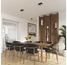 Sufragerie modernă cu masă din lemn, scaune și raft încorporat cu design natural. Corpurile de iluminat plafoniere creează o atmosferă luminoasă.