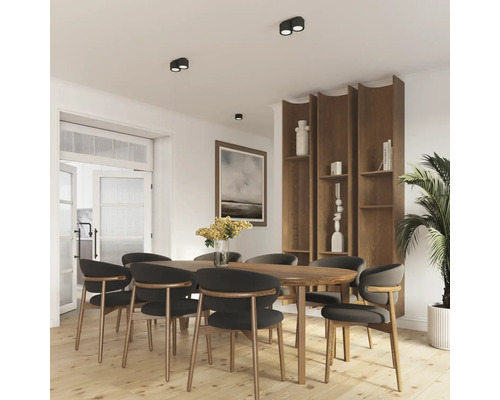 Sufragerie modernă cu masă din lemn, scaune și raft încorporat cu design natural. Corpurile de iluminat plafoniere creează o atmosferă luminoasă.