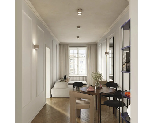 Living modern luminos cu masă de dining scaune canapea și aplice într-un apartament elegant cu parchet și muluri clasice
