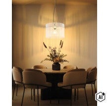 Sufragerie cu masă rotundă, scaune tapițate și o lampă suspendată modernă cu design cu lamele care creează o atmosferă luminoasă caldă. (Image AI modified or generated)