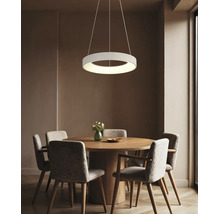 Pendul LED rotund modern deasupra unei mese de sufragerie rotunde din lemn cu patru scaune tapitate intr o sufragerie amenajata elegant.