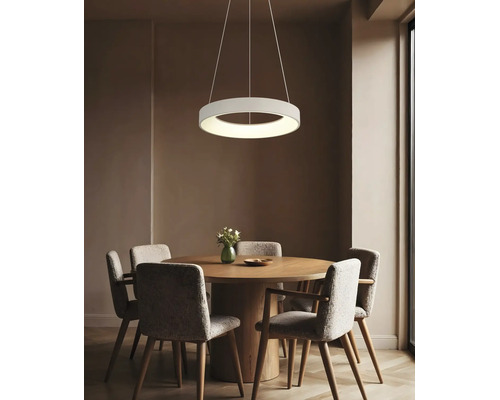 Pendul LED rotund modern deasupra unei mese de sufragerie rotunde din lemn cu patru scaune tapitate intr o sufragerie amenajata elegant.