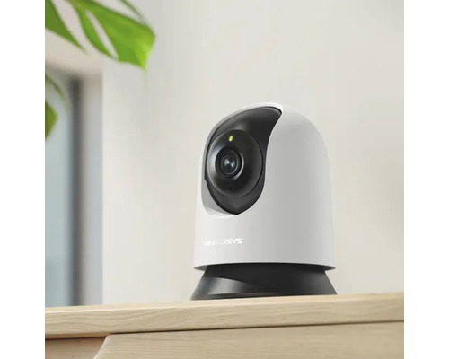 Cameră de supraveghere Wi-Fi pentru interior cu funcție de panoramare și înclinare pe o piesă de mobilier.