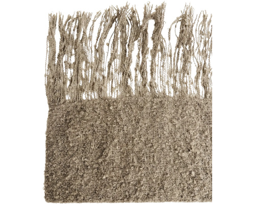 Pătură texturată cu franjuri ca element textil decorativ pentru o atmosferă primitoare.