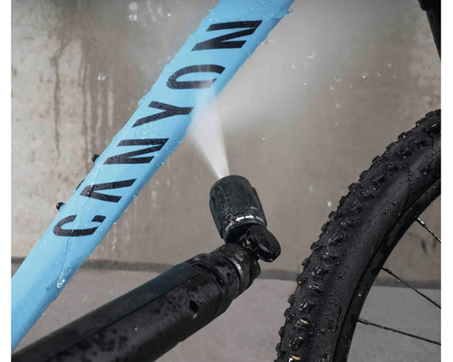 Curățarea bicicletei cu o duză de înaltă presiune care pulverizează apă pe cadrul bicicletei