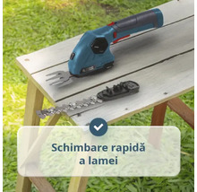 Foarfecă pentru iarbă cu acumulator și lamă interschimbabilă pentru arbuști pentru schimbarea rapidă a lamei pe o masă de lemn.