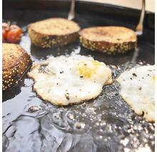 Ouă ochiuri și pâine gătite împreună într-o tigaie de grill din fontă.