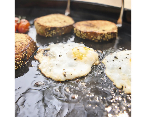 Ouă ochiuri și pâine gătite împreună într-o tigaie de grill din fontă.