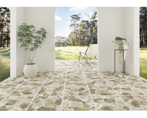 Terasă acoperită cu plăci ceramice cu aspect de piatră naturală, vedere către o grădină cu un șezlong, un ghiveci și o vază pe suport.