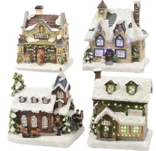 Patru case miniaturale de Crăciun acoperite cu zăpadă și iluminate.