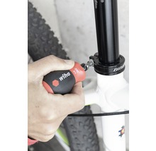 O persoană fixează o tijă de șa de bicicletă cu o șurubelniță Wiha.