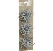 Trei flori decorative argintii, strălucitoare, pe o carte de carton.