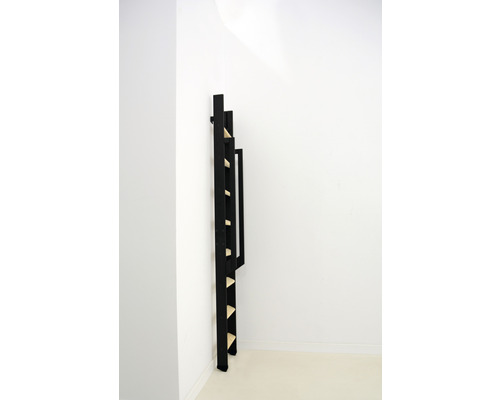 Bibliotecă scară neagră din lemn sprijinită de un perete alb