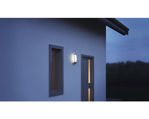 Lumină de perete exterioară lângă fereastră și ușă pe peretele casei