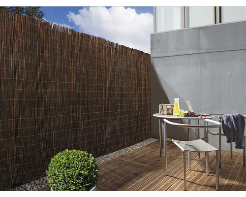 Gard de protecție vizuală din stuf pe o terasă cu masă și scaune