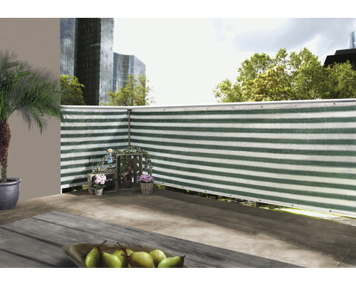 Scenă a unui balcon cu paravan de confidențialitate, decorat cu flori și un palmier într-un ghiveci