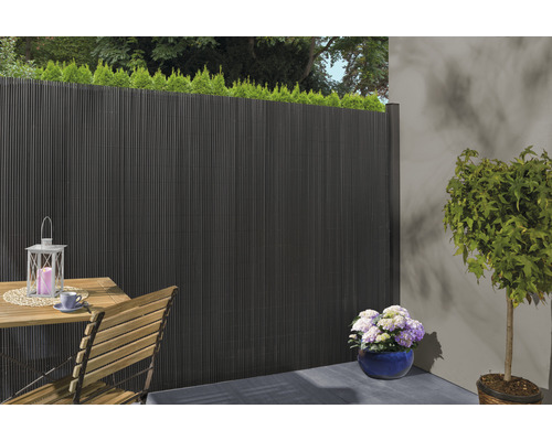 Scenă de terasă cu paravan de intimitate, masă, scaun și plante