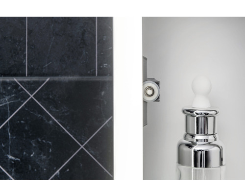 Prim-plan al unei băi cu gresie, rolă de cabină de duș și un dispenser