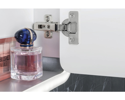 Balamaua pe un dulap alb cu produse cosmetice