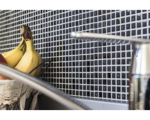 Plăci de perete cu model mozaic în spatele unei chiuvete cu robinet și coș de fructe