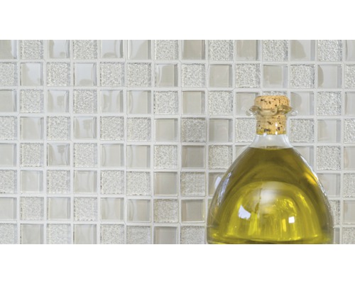 Plăci de mozaic din sticlă cu o sticlă de ulei în prim-plan