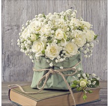 Buchet de trandafiri albi și gipsofila într-o pungă de hârtie verde pe o carte