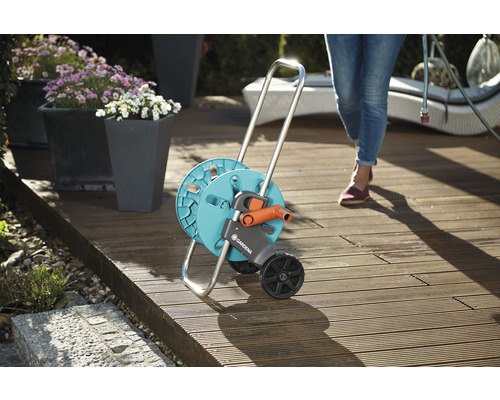 Cărucior furtun de grădină cu roți pe o terasă din lemn