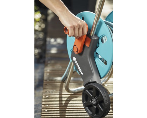 Persoană care operează o rolă de furtun Gardena cu roți