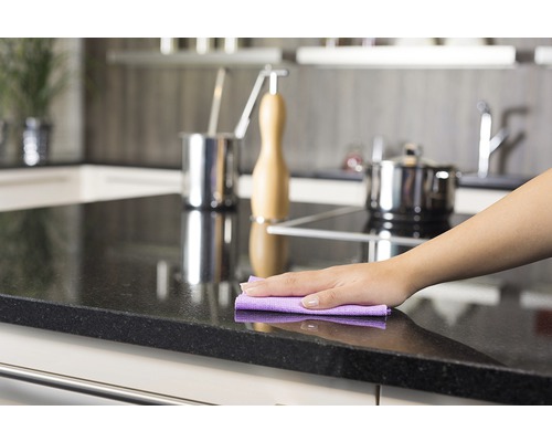 Curățarea unui blat de bucătărie cu o cârpă de curățare