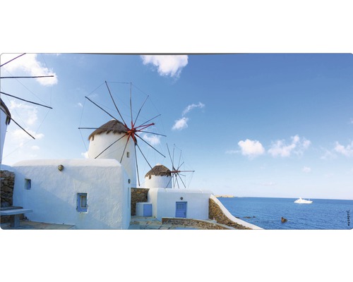 Panoramă cu mori de vânt și clădiri văruite în alb pe malul mării