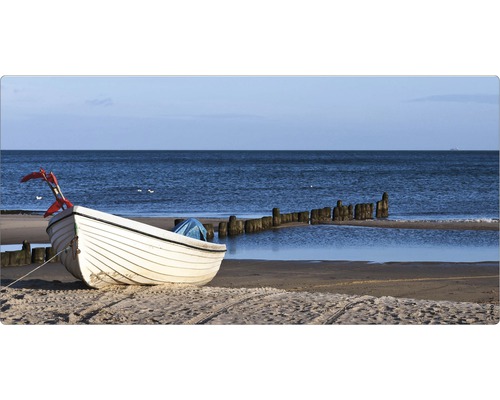 O barcă albă zace pe plajă cu vedere la mare