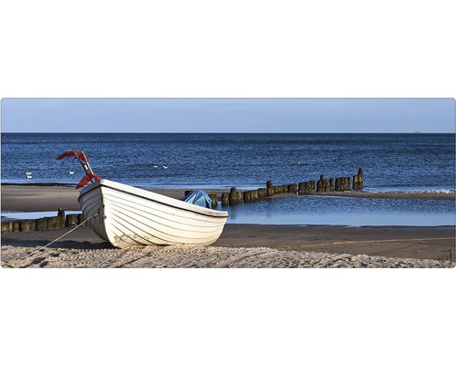 O barcă albă zace pe plajă