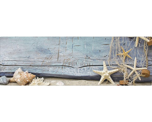 Aranjament decorativ cu scoici, stele de mare și plasă de pescuit pe nisip în fața unui fundal din lemn