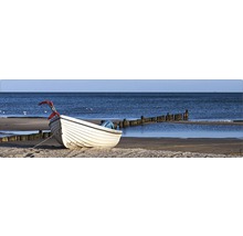 Barcă pe plajă cu stâlpi de lemn în apă