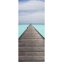 Pasarelă din lemn peste apă turcoaz sub un cer senin.