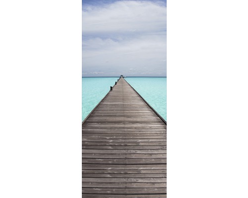 Pasarelă din lemn peste apă turcoaz sub un cer senin.