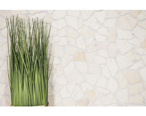 Plantă artificială decorativă în fața unui perete de piatră