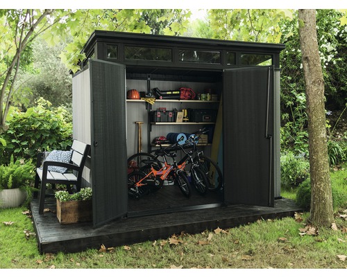 Cabină de grădină cu uși deschise, interior cu rafturi, biciclete și unelte de grădină