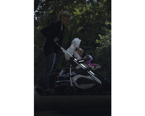 O femeie împinge un cărucior cu un copil în el.